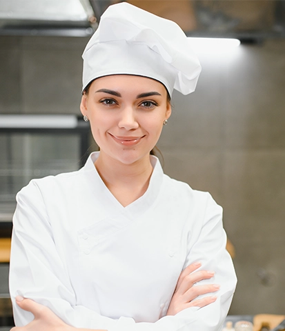 Qualified hospitality worker preparing food in a professional kitchen.